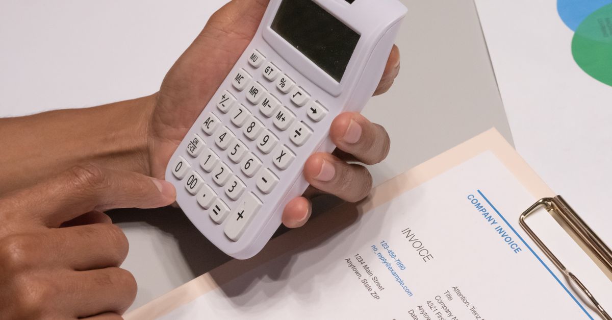 Calculadora e documentos fiscais sobre mesa de trabalho
